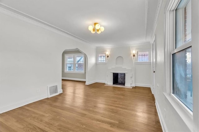 1122 E 76th St, Kansas City, MO 64131 - unfurnished living room featuring arched walkways, wood finished floors, visible vents, and crown molding