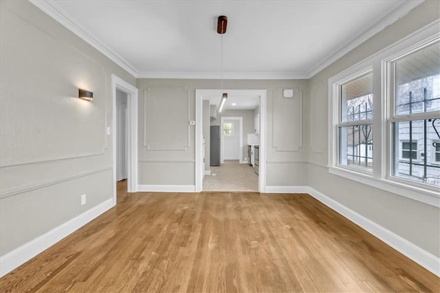 1122 E 76th St, Kansas City, MO 64131 - unfurnished dining area with ornamental molding, plenty of natural light, and light wood-style floors