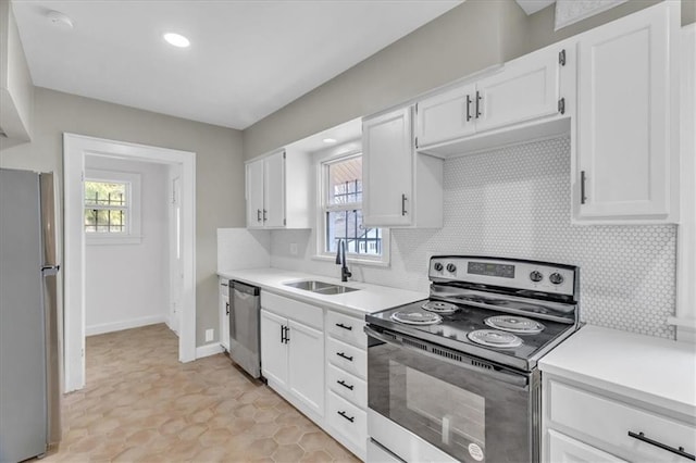 1122 E 76th St, Kansas City, MO 64131 - kitchen with appliances with stainless steel finishes, light countertops, a sink, and white cabinetry