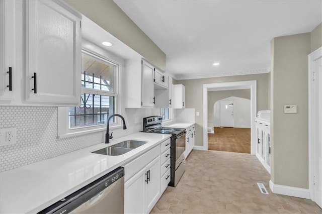 1122 E 76th St, Kansas City, MO 64131 - kitchen featuring tasteful backsplash, stainless steel appliances, light countertops, white cabinetry, and a sink