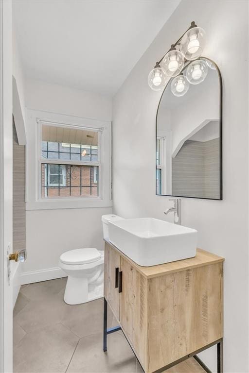 1122 E 76th St, Kansas City, MO 64131 - bathroom with baseboards, vanity, and toilet