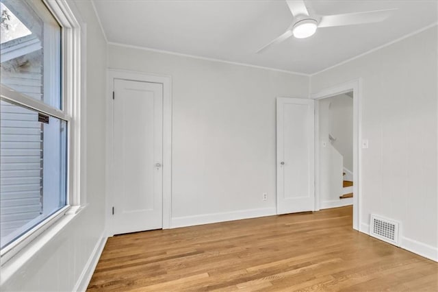 1122 E 76th St, Kansas City, MO 64131 - spare room with visible vents, baseboards, ceiling fan, ornamental molding, and light wood-type flooring