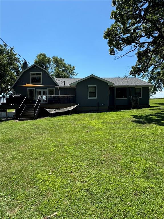 rear view of property featuring a deck and a lawn