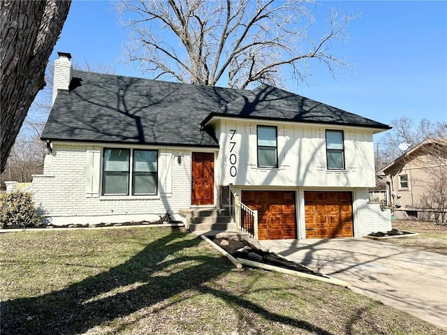 tri-level home featuring a front lawn, concrete driveway, an attached garage, brick siding, and a chimney