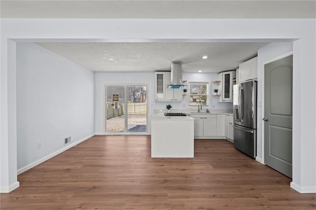 kitchen with a sink, open shelves, white cabinetry, stainless steel appliances, and island range hood