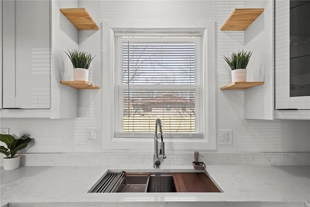 kitchen featuring open shelves, white cabinets, plenty of natural light, and a sink