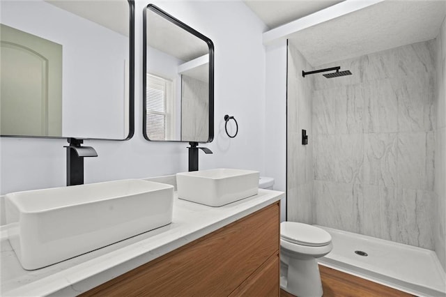 bathroom featuring a stall shower, toilet, vanity, and wood finished floors