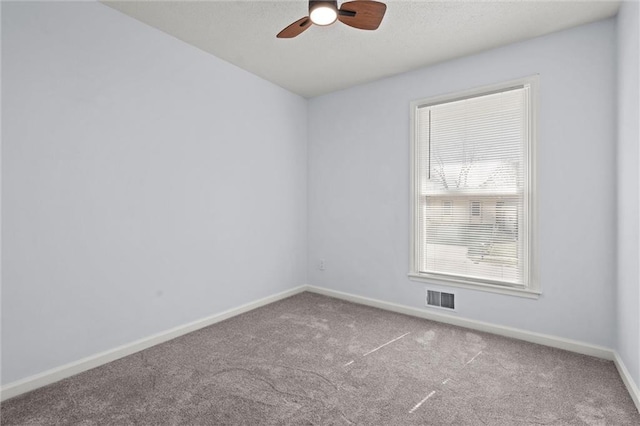 carpeted empty room featuring visible vents, ceiling fan, and baseboards