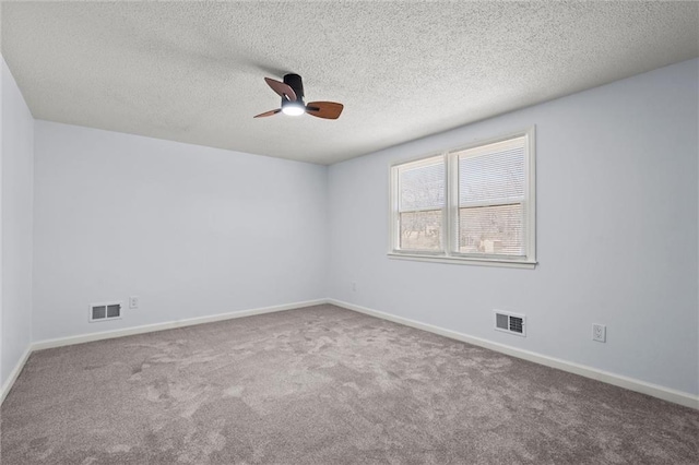 carpeted spare room with a ceiling fan, baseboards, visible vents, and a textured ceiling