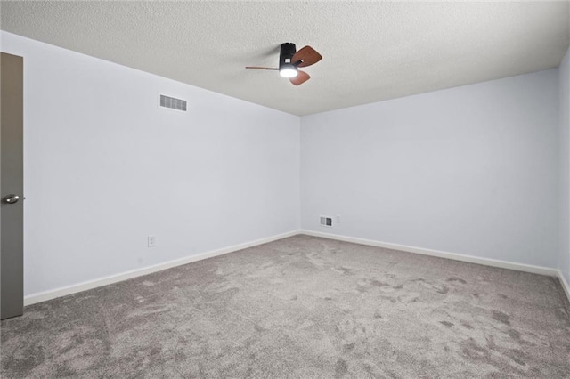 carpeted empty room featuring baseboards, a ceiling fan, visible vents, and a textured ceiling