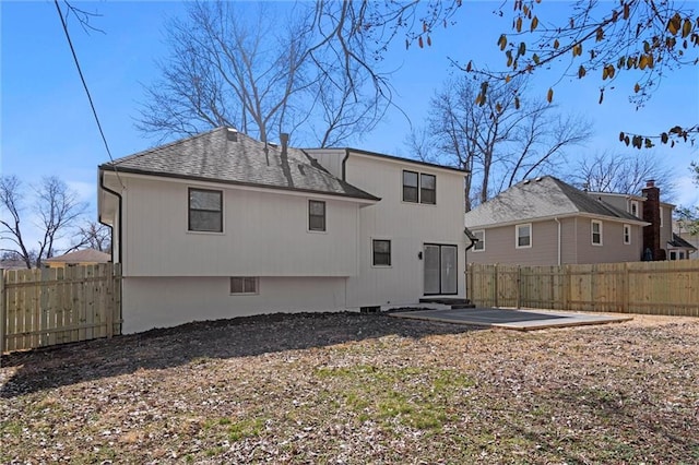 back of house featuring fence private yard, a patio, and a shingled roof