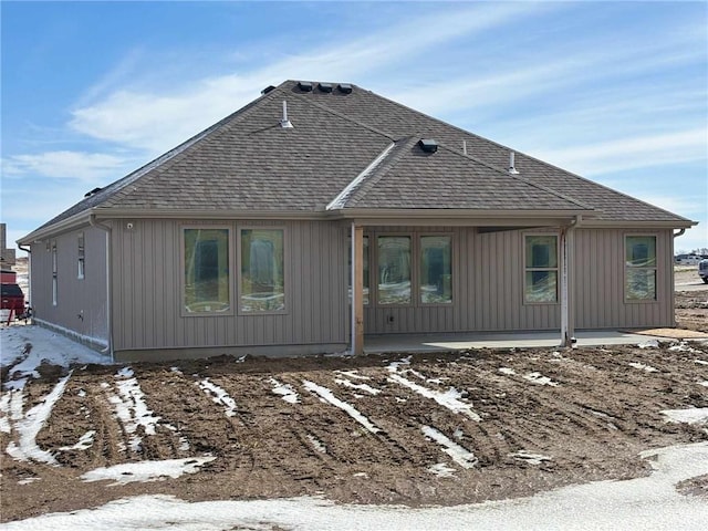 back of house featuring a shingled roof