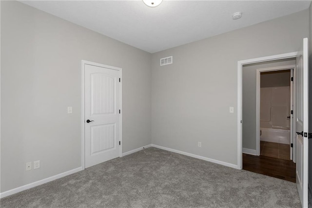 spare room with baseboards, visible vents, and carpet flooring