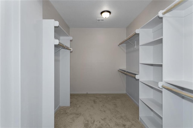 spacious closet featuring visible vents and light colored carpet