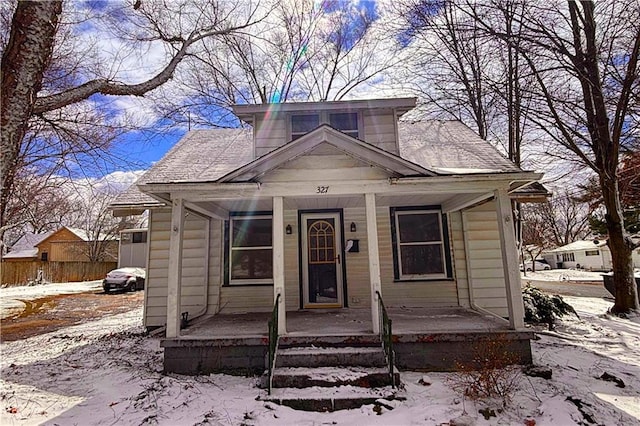 bungalow-style home featuring covered porch and a shingled roof