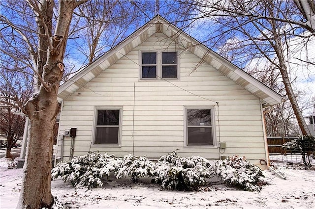 view of snow covered exterior with fence