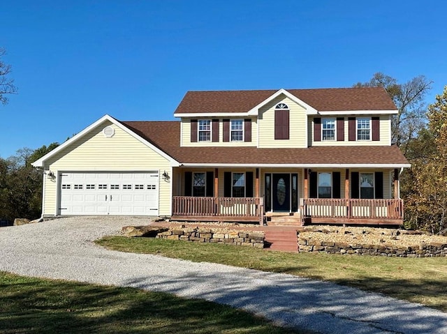 view of front of property with gravel driveway, covered porch, an attached garage, and roof with shingles