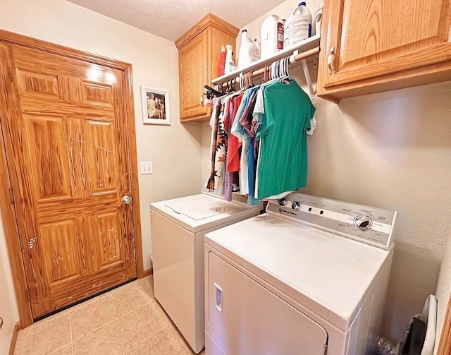 laundry room featuring light tile patterned floors, cabinet space, and washer and dryer