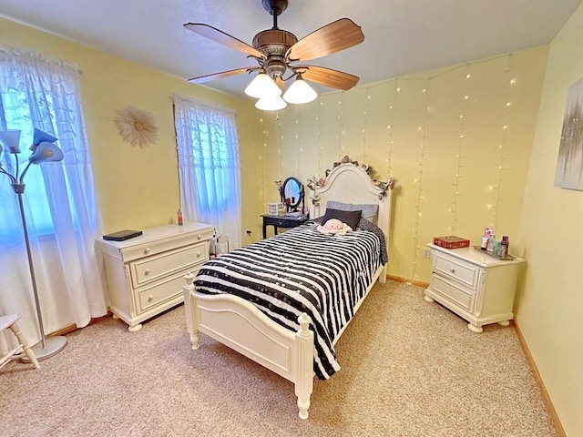 bedroom featuring light carpet, ceiling fan, and baseboards