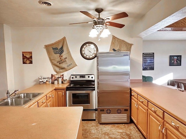 kitchen featuring stainless steel appliances, a peninsula, a sink, visible vents, and light countertops