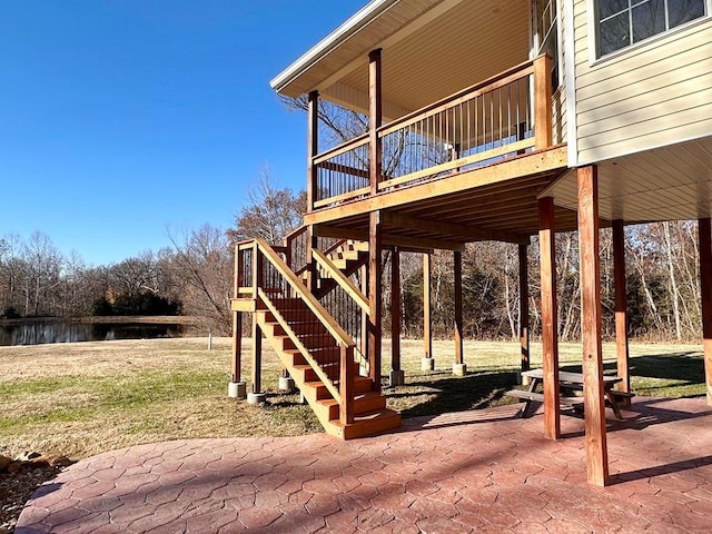 exterior space with a patio, stairway, and a water view