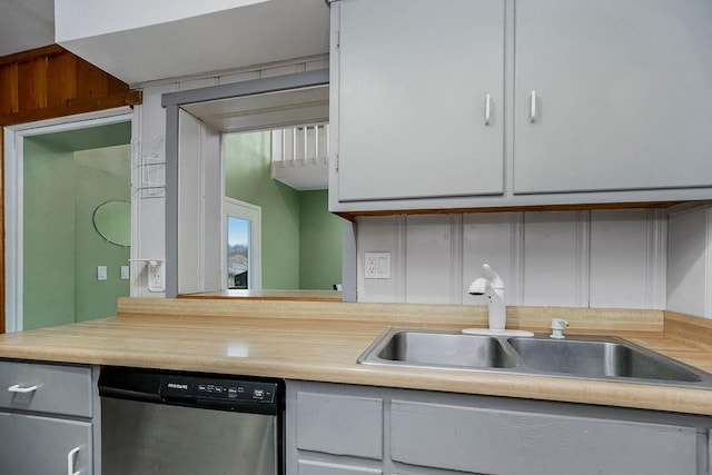 kitchen featuring light countertops, dishwasher, and a sink