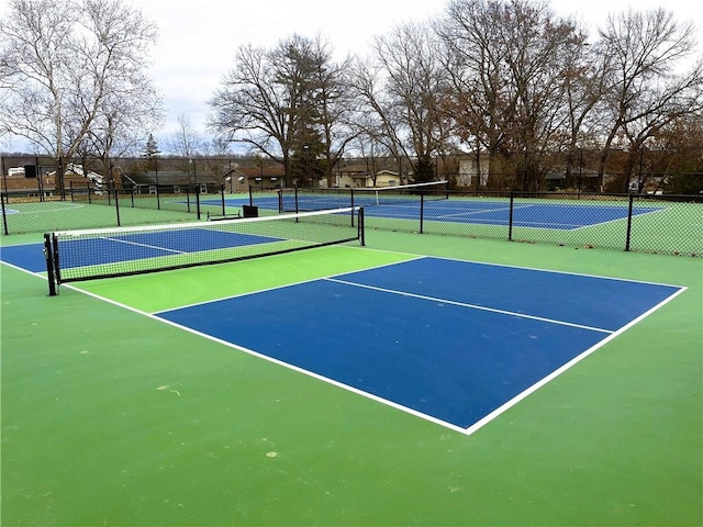 view of tennis court with community basketball court and fence