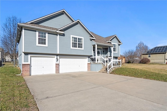 split foyer home with an attached garage, a shingled roof, a front lawn, concrete driveway, and brick siding