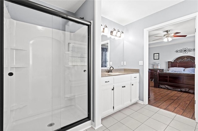 ensuite bathroom featuring tile patterned floors, connected bathroom, a stall shower, and vanity