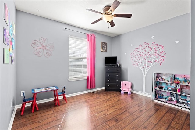 game room with a ceiling fan, baseboards, and wood finished floors