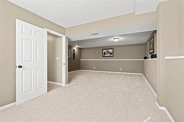 finished basement with visible vents, carpet floors, and baseboards