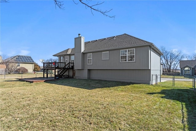 back of property with a lawn, fence, stairway, a wooden deck, and a chimney