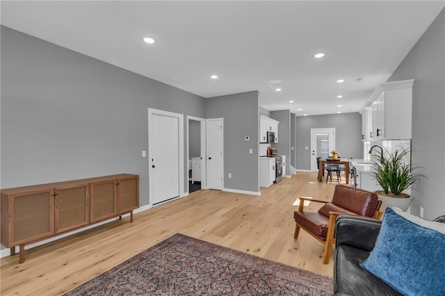 living area featuring light wood-style flooring, recessed lighting, and baseboards