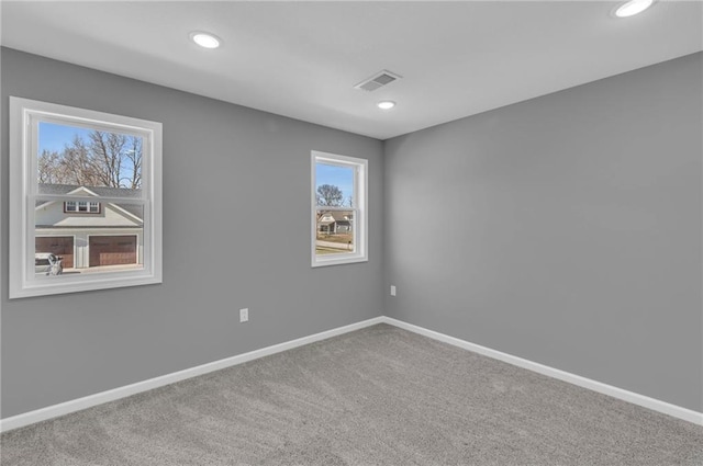 empty room with visible vents, recessed lighting, baseboards, and carpet floors