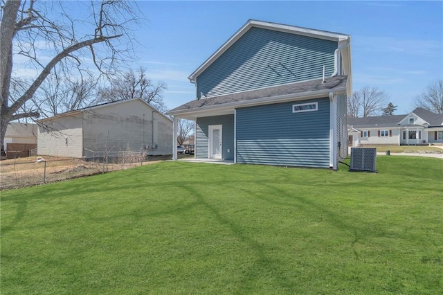 back of property featuring central air condition unit and a yard