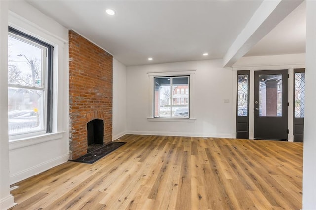 entryway featuring recessed lighting, a brick fireplace, baseboards, and wood finished floors