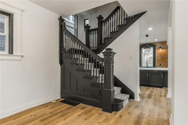 stairway featuring recessed lighting, visible vents, baseboards, and wood finished floors