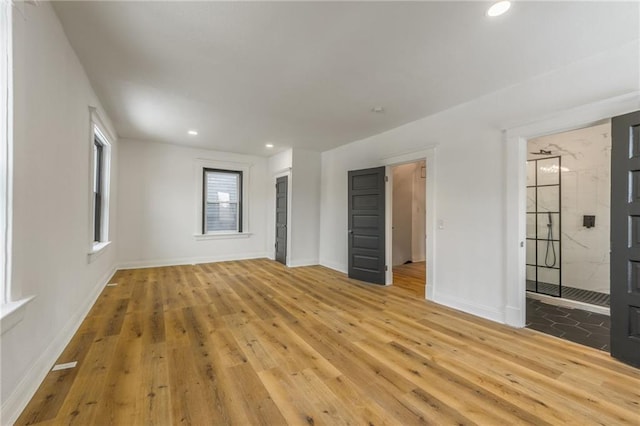 spare room featuring wood-type flooring, baseboards, and recessed lighting