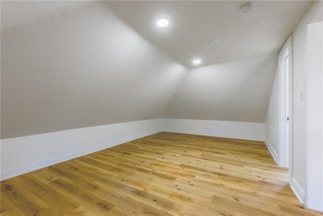 bonus room with vaulted ceiling, light wood finished floors, baseboards, and recessed lighting