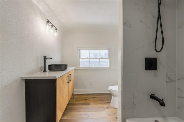 bathroom with toilet, vanity, wood finished floors, baseboards, and walk in shower