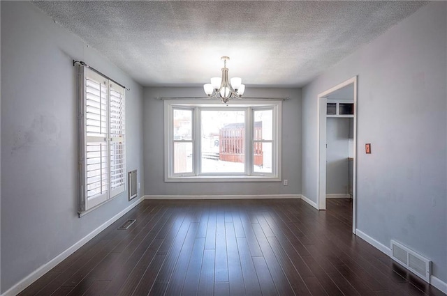 unfurnished dining area featuring an inviting chandelier, baseboards, visible vents, and dark wood-style flooring