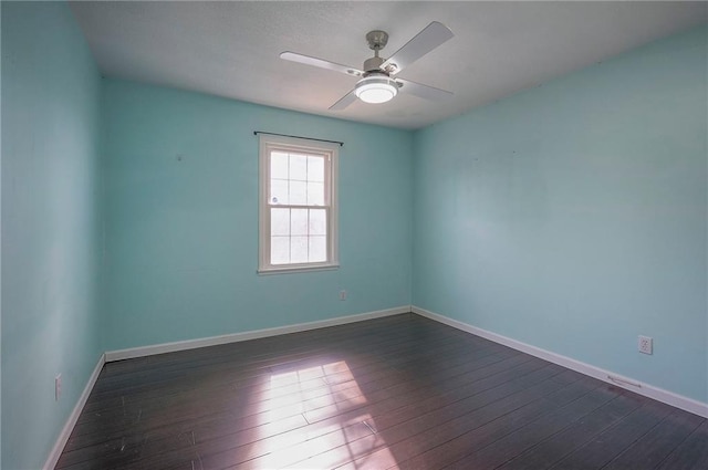 unfurnished room with a ceiling fan, dark wood-style flooring, and baseboards