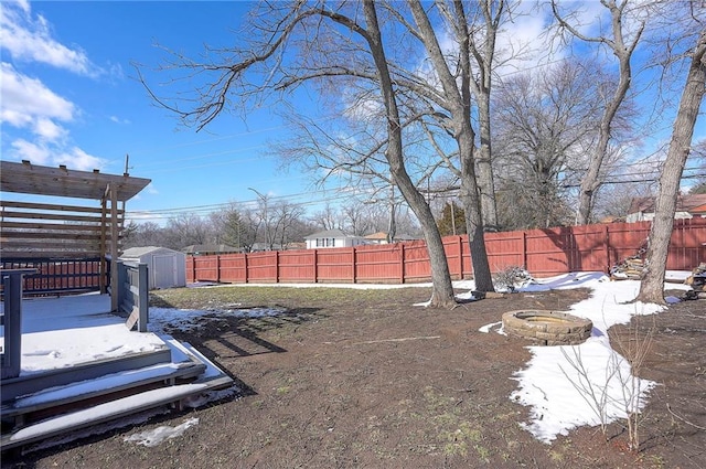 view of yard with an outbuilding, a storage unit, an outdoor fire pit, and a fenced backyard