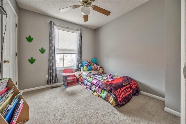 carpeted bedroom featuring a textured ceiling, ceiling fan, visible vents, and baseboards