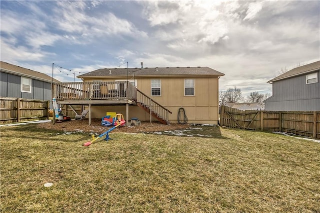 rear view of property featuring a fenced backyard, a lawn, a deck, and stairs