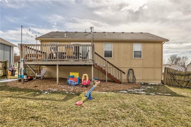 back of property with a yard, stairway, a wooden deck, and fence