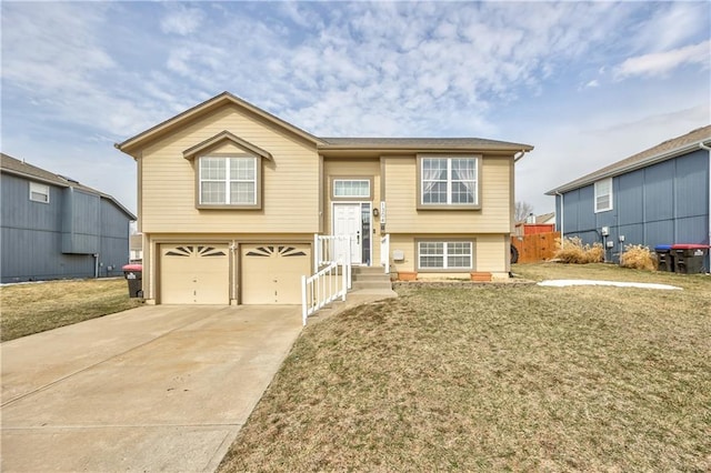 raised ranch featuring a front yard, driveway, and an attached garage