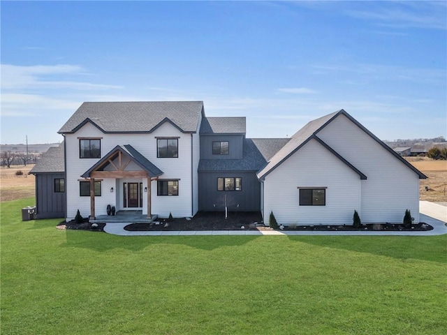 modern inspired farmhouse with roof with shingles and a front yard