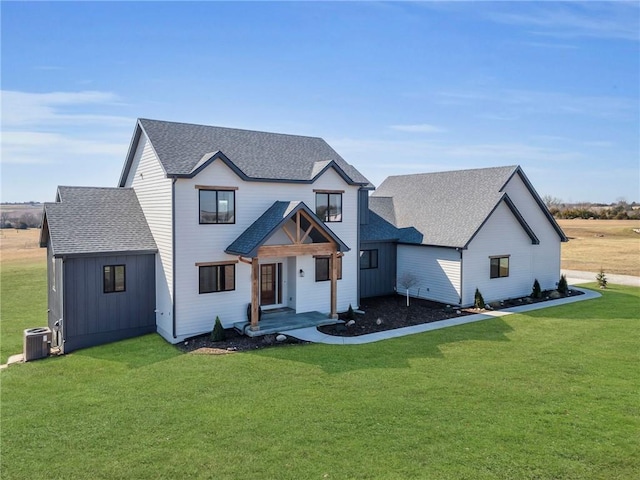 modern farmhouse featuring a front yard, central air condition unit, and a shingled roof