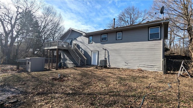 back of property with central AC unit, a wooden deck, and stairs